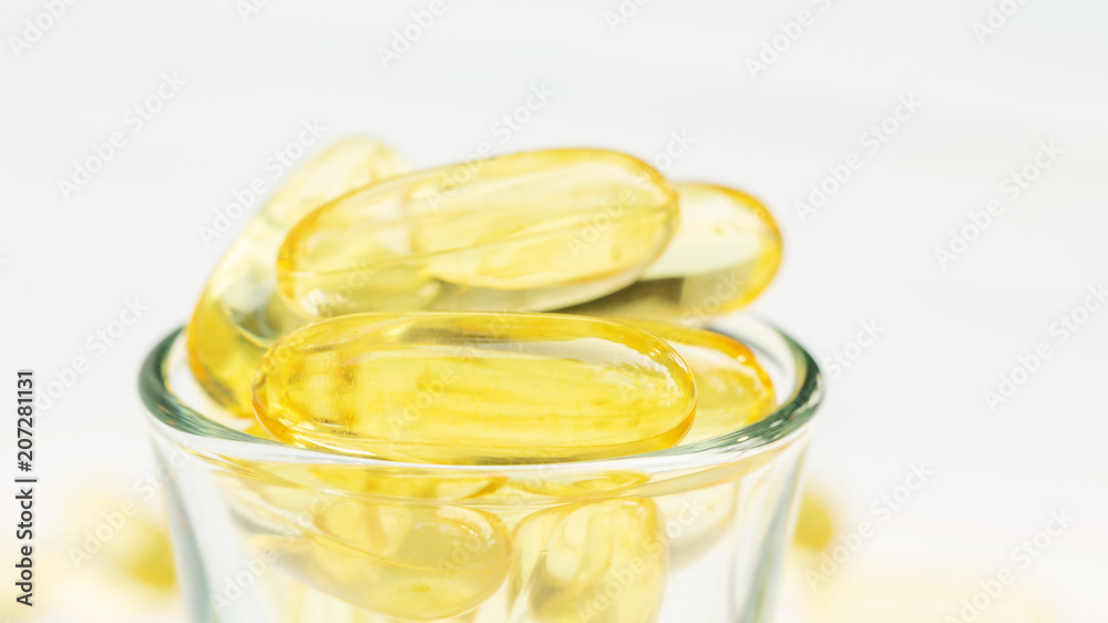 Fish oil in a glass on a white wooden table. Fish oil in a glass on a white wooden table.