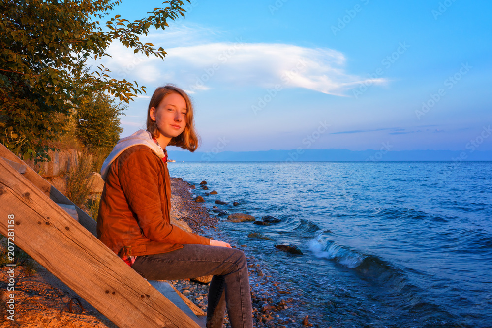 Portrait of young beautiful lady admiring the summer landscape o