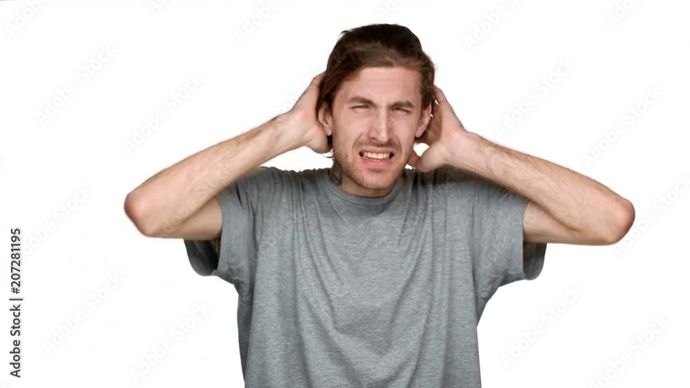 Portrait of tall caucasian guy covering ears and screaming because of annoying noise or loud music, isolated over white background. Concept of emotions Portrait of tall caucasian guy covering ears and screaming because of annoying noise or loud music, isolated over white background. Concept of emotions
