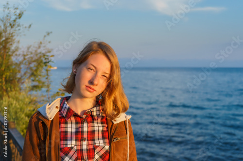 Portrait of young beautiful lady in the summer at sunset on the