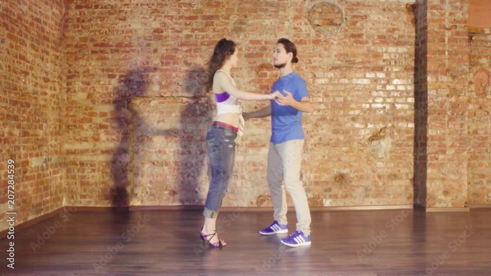 Couple dancing in the hall on the background of old brick wall Couple dancing in the hall on the background of old brick wall
