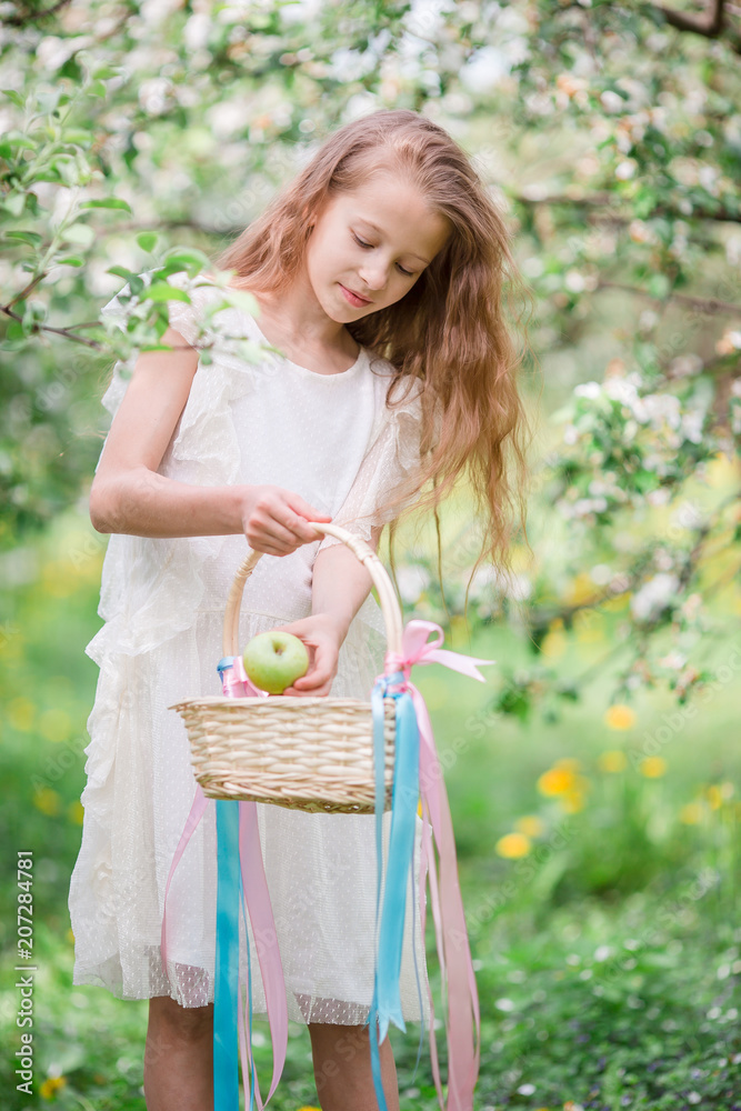 Adorable little girl in blooming apple garden on beautiful spring day Adorable little girl in blooming apple garden on beautiful spring day