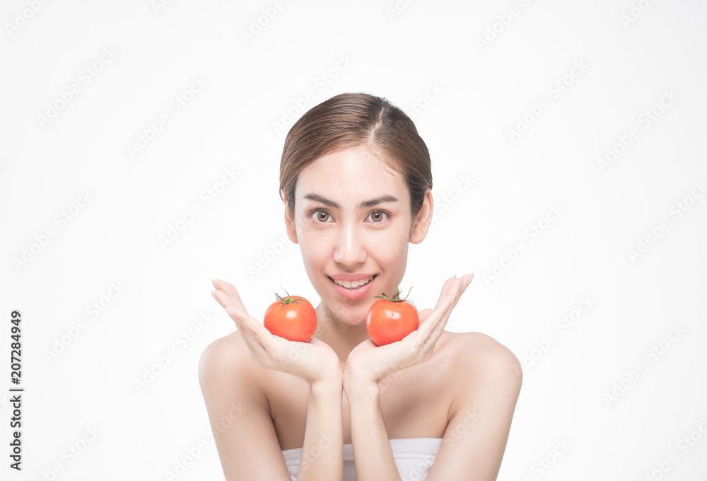 beautiful asia woman with towel on head with perfect clean skin smiling holding tomato slices over white background. Beauty cosmetology and spa. beautiful asia woman with towel on head with perfect clean skin smiling holding tomato slices over white background. Beauty cosmetology and spa.
