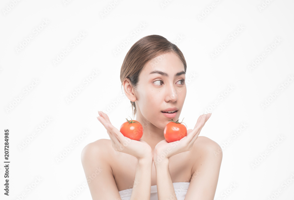 beautiful asia woman with towel on head with perfect clean skin smiling holding tomato slices over white background. Beauty cosmetology and spa. beautiful asia woman with towel on head with perfect clean skin smiling holding tomato slices over white background. Beauty cosmetology and spa.