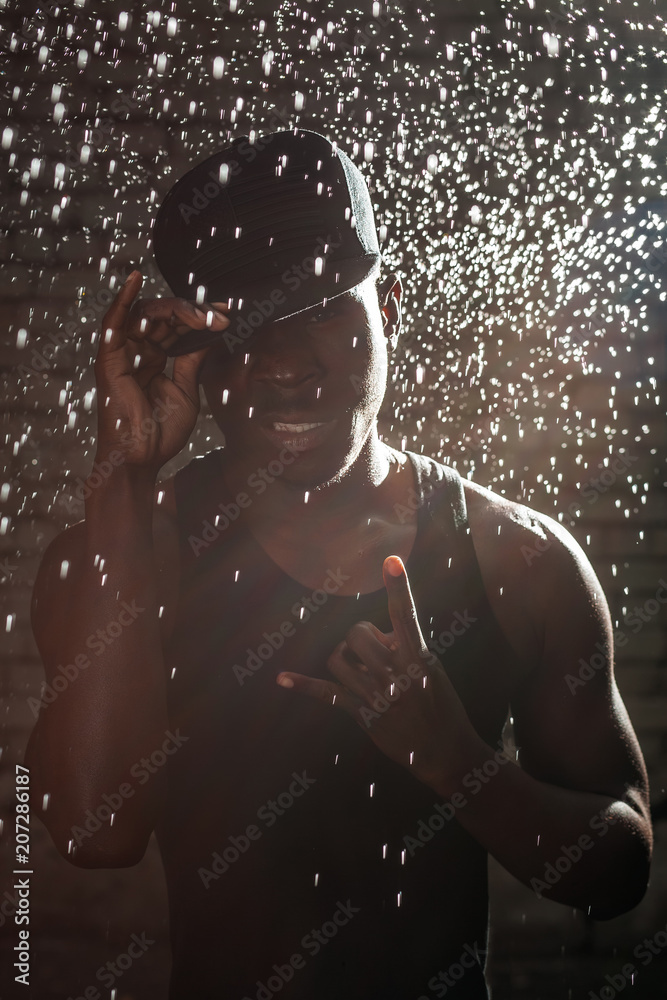 black man in the rain on the wall background