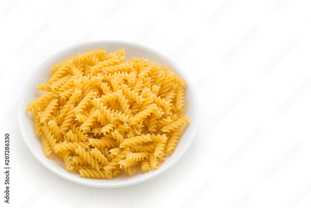 raw pasta in white plate on isolated white background

