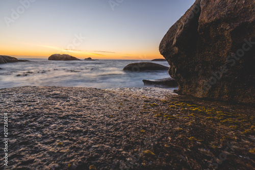 Long exposure of Atlantic ocean at sunset with rocks