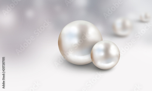 Two large white with blurred pearls in background on grey and white cloudy background