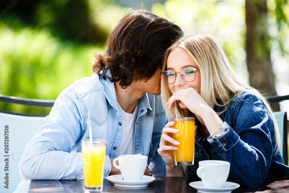 Young romantic couple spending time together - sitting in cafe's garden Young romantic couple spending time together - sitting in cafe's garden