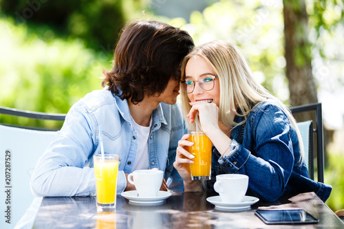 Young romantic couple spending time together - sitting in cafe's garden