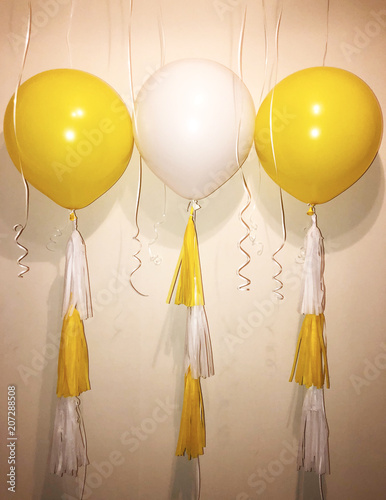 Huge helium balloons of yellow and white colors with garlands-tassels. Party in the style of "chamomile"