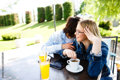 Young romantic couple spending time together - sitting in cafe's garden