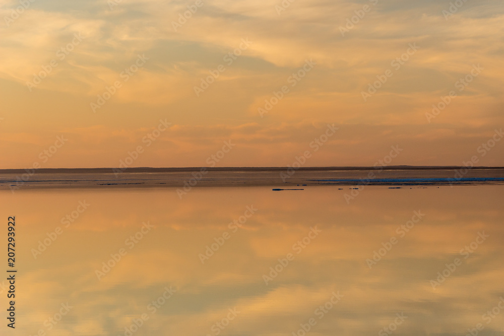 Sea surface with reflection of sky and clouds at sunset Sea surface with reflection of sky and clouds at sunset