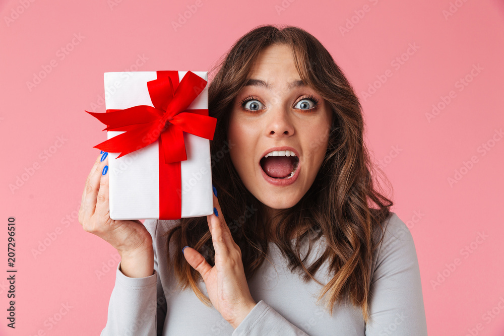 Shocked young pretty woman holding surprise gift present box. Shocked young pretty woman holding surprise gift present box.
