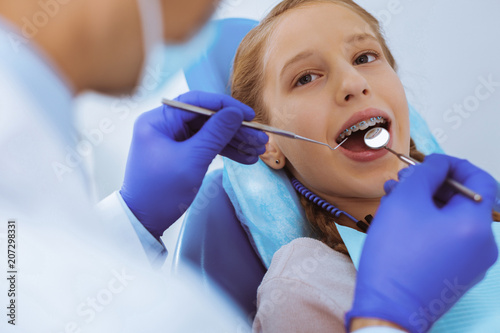 Being thankful. Beautiful girl keeping mouth opened while visiting doctor