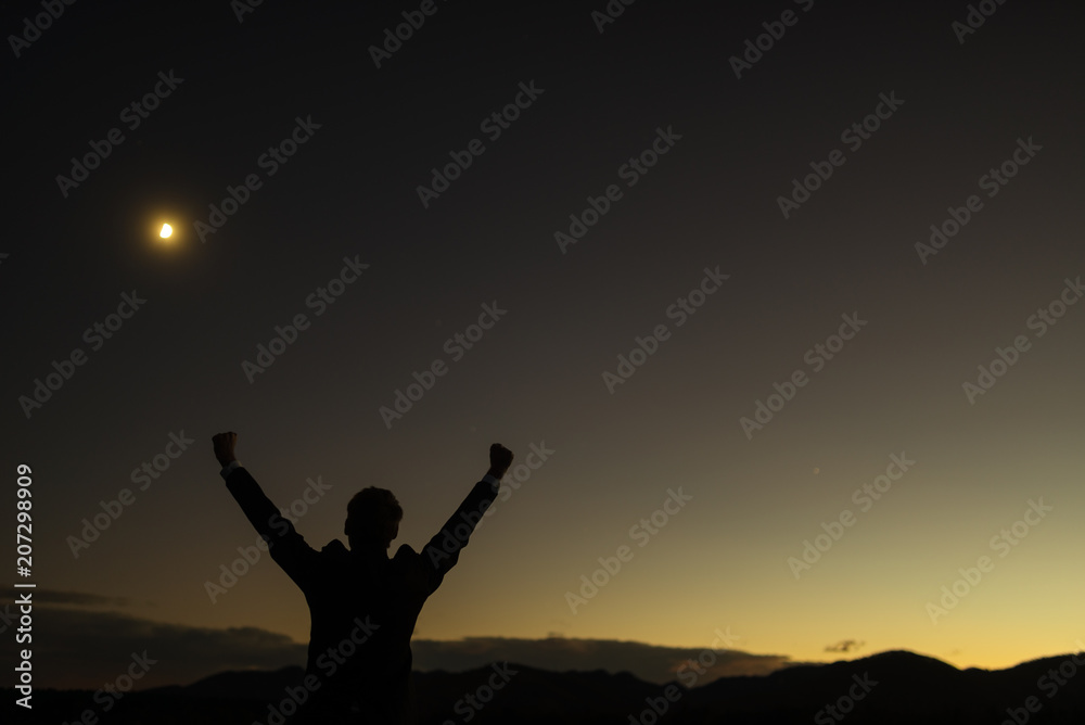 Triumphant businessman greeting a new day standing outdoors