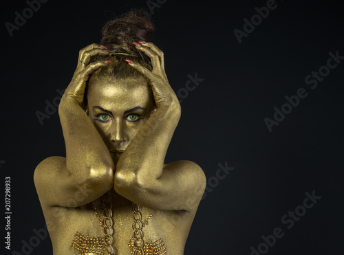 woman fully dressed in gold  on black background