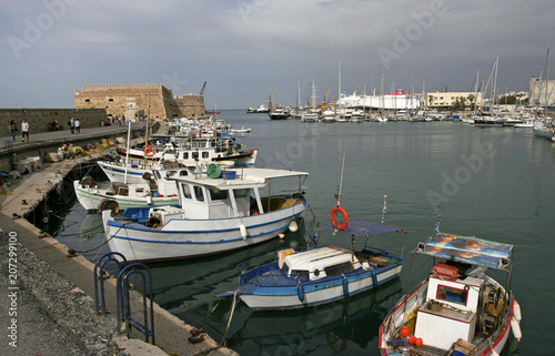 The white boats in the marina near the old fortress in the small Mediterranean town on the sunny day.