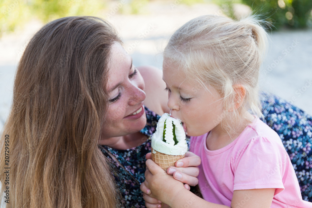 Mom and child eat ice cream, happy family moment. Mom and child eat ice cream, happy family moment.