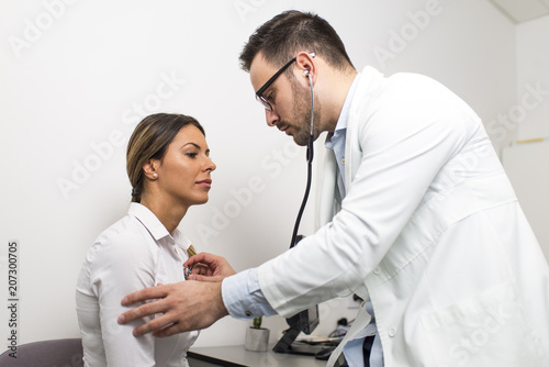 Male doctor examines a fema...