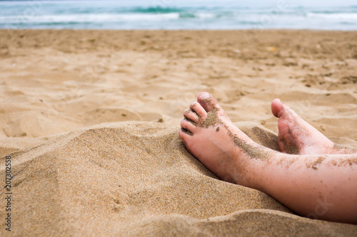 Child feet in the sand on a...