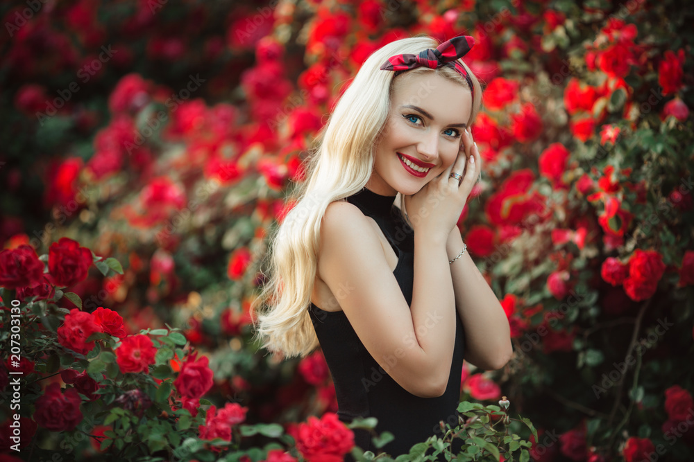 Beautiful blonde woman in bush of red roses Beautiful blonde woman in bush of red roses