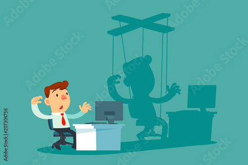 businessman at office desk and his shadow as puppet