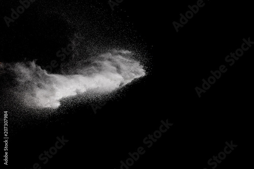 Freeze motion of white particles on black background. Abstract white dust explosion.