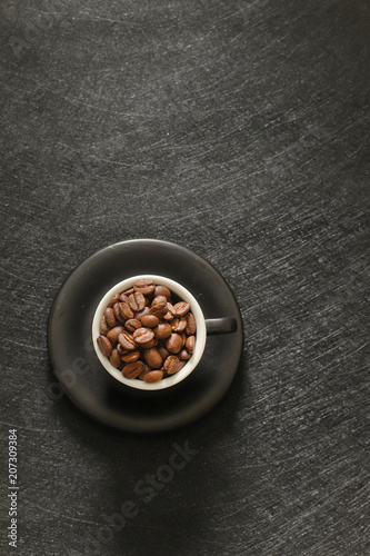 Cup of coffee beans isolated on black