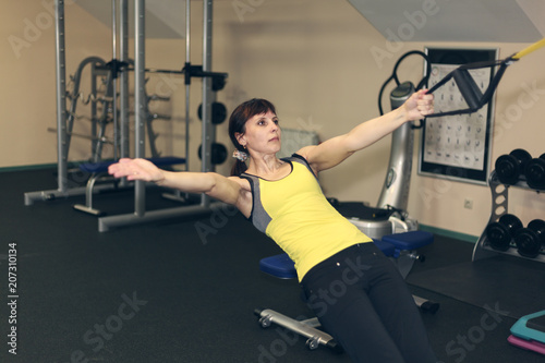 fitness exercises, a woman performs an exercise bar bench press on the shoulders