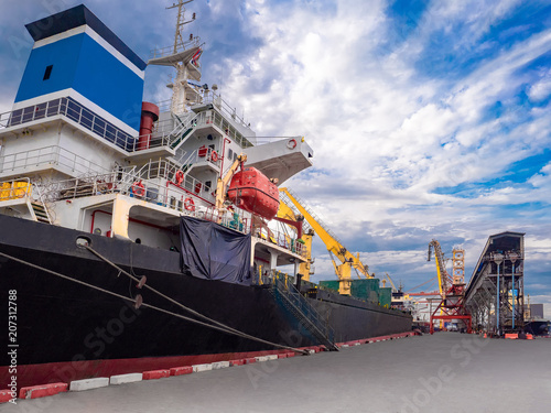 Bulk Vessel alongside at thailand port and loading bulk cargo by  shiploader. photo