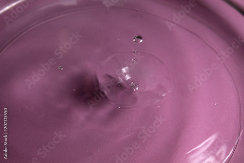 gota de agua salpicando en fondo rosa