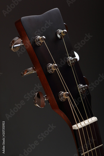 Six-stringed wooden acoustic guitar head with tuning pegs