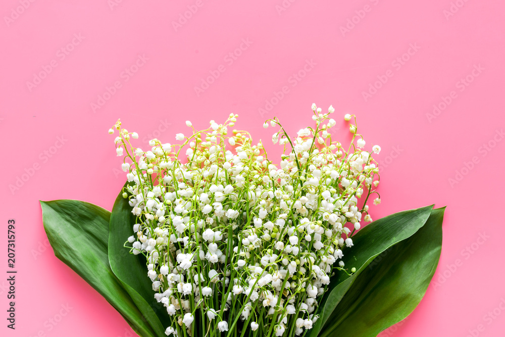 May flowers. Bouqet of lily of the valley flowers on pastel pink background top view copy space