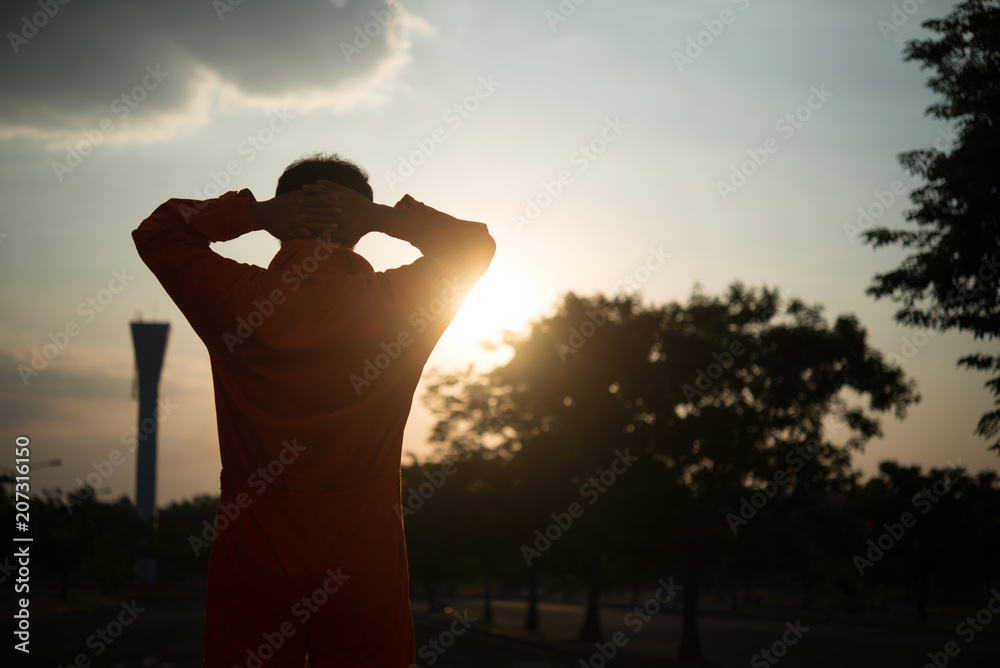Fototapeta premium Silhouette Portrait of asian handsome man in Prison uniforms,He has a lot Mustache and messy hair,Thailand people angry,Prisoner concept on sunset