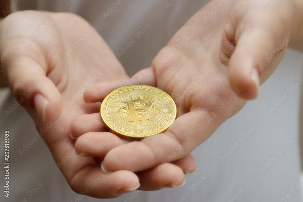 Fototapeta premium female hands closeup with the coin bitcoin