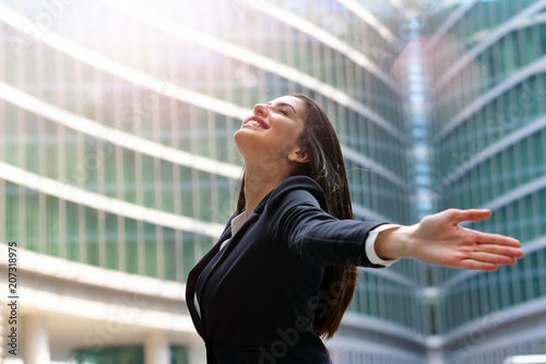 An asian business woman, dressed in a suit, raises her arms to the sky and breathes as a sign of freedom and success in her work. Free Download An asian business woman, dressed in a suit, raises her arms to the sky and breathes as a sign of freedom and success in her work. - GFXLoad