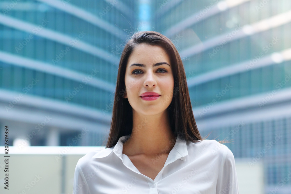 Fototapeta premium Portrait of a business woman, in a suit and tie, happy and smiling as she looks at the camera and crosses her arms, proud of her work. Concept of: success, finance and female career