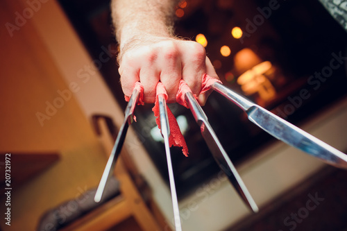 Famous wolverine claws heroic gesture, man hand holding three wooden drumsticks over black background, back view, horizontal photo