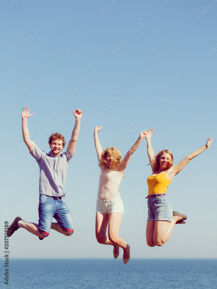 Group of friends boy two girls jumping outdoor Group of friends boy two girls jumping outdoor