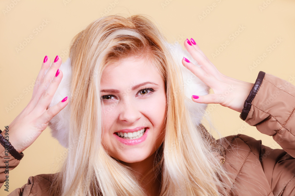 Fototapeta premium Blonde woman in winter earmuffs and jacket.
