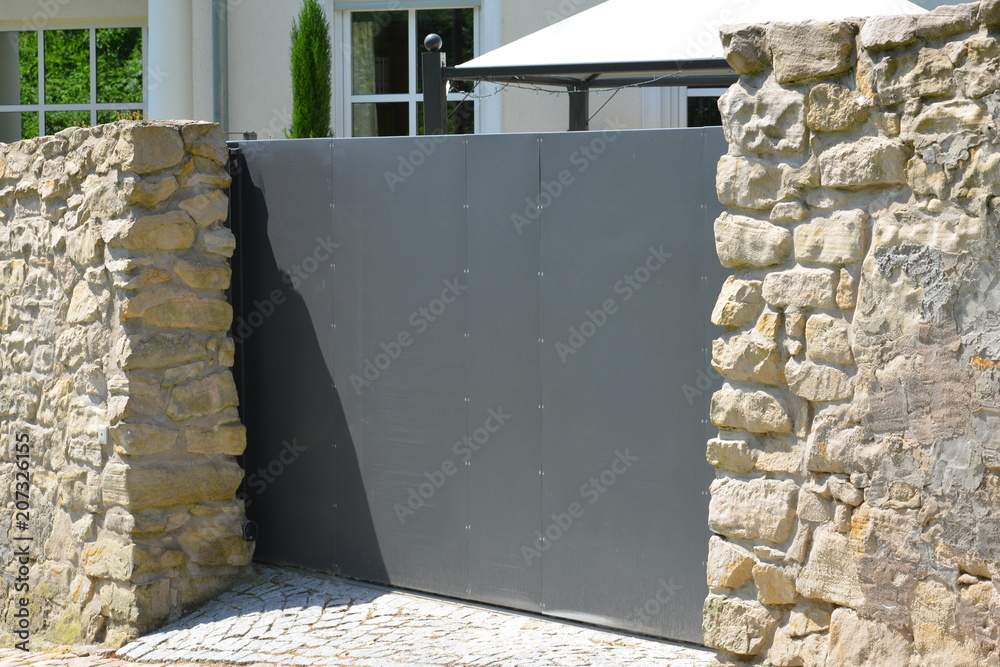 Naklejka premium Naturstein-gemauerte Hofzufahrt eines Wohngebäudes mit Automatik-Schiebetor