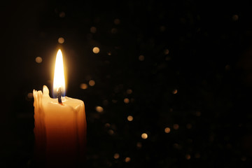 Candles Burning at Night. White Candles Burning in the Dark with focus on single candle in foreground. 