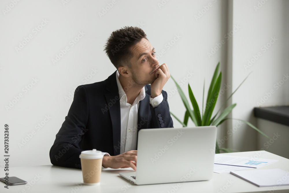 Bored tired millennial businessman in suit feeling dull working on laptop at workplace, absent-minded employee thinking or boring monotonous office routine, no motivation and lack of ideas concept Bored tired millennial businessman in suit feeling dull working on laptop at workplace, absent-minded employee thinking or boring monotonous office routine, no motivation and lack of ideas concept