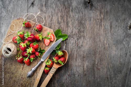 Sweet strawberries on the wooden background. Top view. Free space