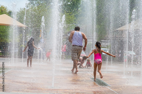Fotografi It's hot, children and adults run barefoot under streams of water