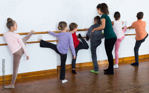calm boys and girls rehearsing ballet dance in studio