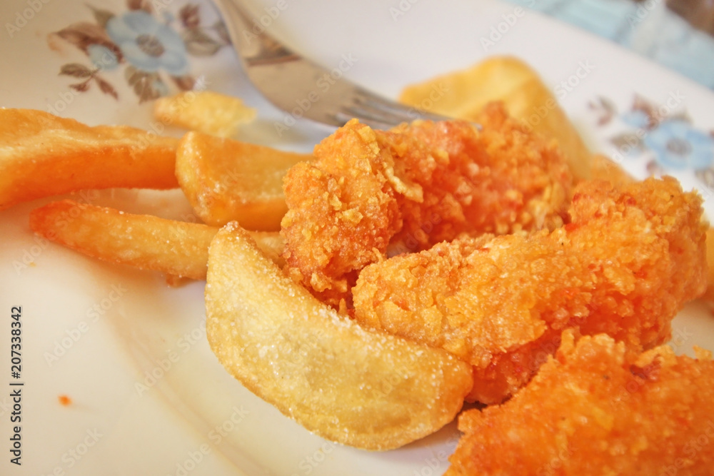 Close up of crispy chicken nuggets with French fries Close up of crispy chicken nuggets with French fries