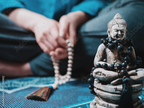 Photography Concentrated woman praying with wooden rosary mala beads