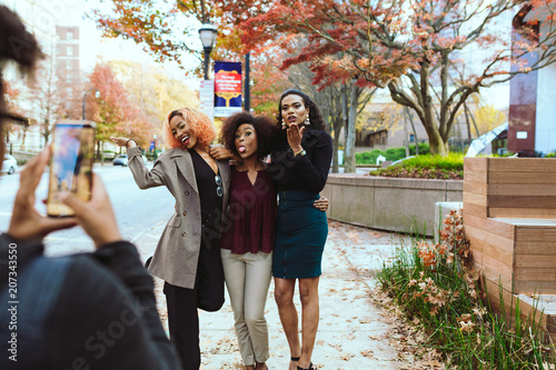 Businesswoman taking photograph of her colleagues with smartphone photo